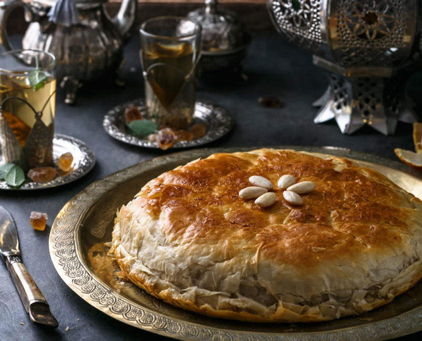 Bastilla dorée servie sur un plateau de cuivre, avec le thé à la menthe